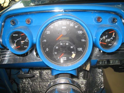 1957 Chevrolet Bel Air - The interior of a 1957 Chevrolet Bel Air features a bright blue dashboard with a prominent speedometer and auxiliary gauges.