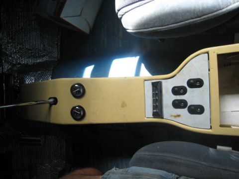 1957 Chevrolet Bel Air - The center console of a car's interior features a yellow finish and a panel with multiple buttons.