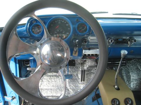 1957 Chevrolet Bel Air - The interior of a 1957 Chevrolet Bel Air features a custom steering wheel and a bright blue dashboard with prominent gauges.