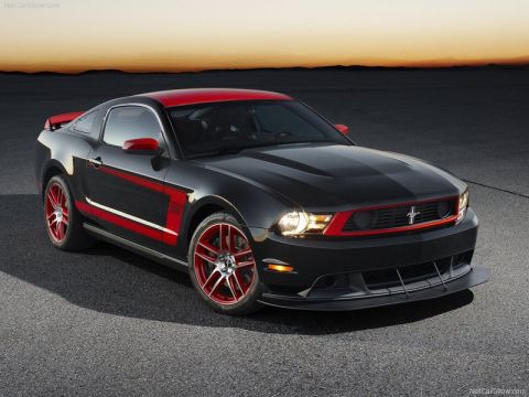1973 Ford Ranchero - Studio-style promotional photo of a black Ford Mustang Boss 302 Laguna Seca fastback shot from the front three-quarter at dusk on open pave…