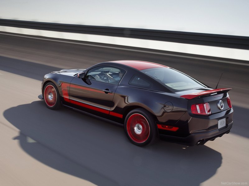 Black Ford Mustang with red racing stripes and red wheels driving on a highway