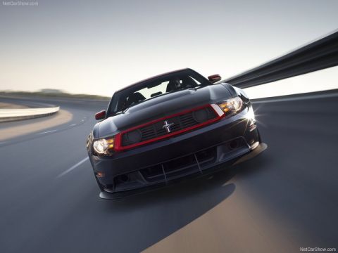 1973 Ford Ranchero - Low head-on press-style rolling shot of a black Ford Mustang Boss 302 Laguna Seca with red grille and headlight accents, running-pony badge…