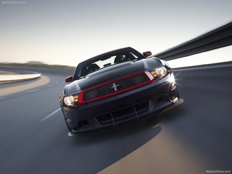 Black Mustang Boss 302 Laguna Seca with red grille trim in motion on racetrack