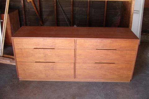 1993 Ford Taurus - A wooden dresser with a dark wood top and lighter wood drawers is shown in a garage setting.