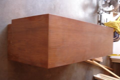 1993 Ford Taurus - A wooden cabinet is shown resting on a concrete floor with some tools in the background.