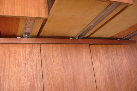 1993 Ford Taurus - Close-up view of drawer slides within a wooden cabinet structure.