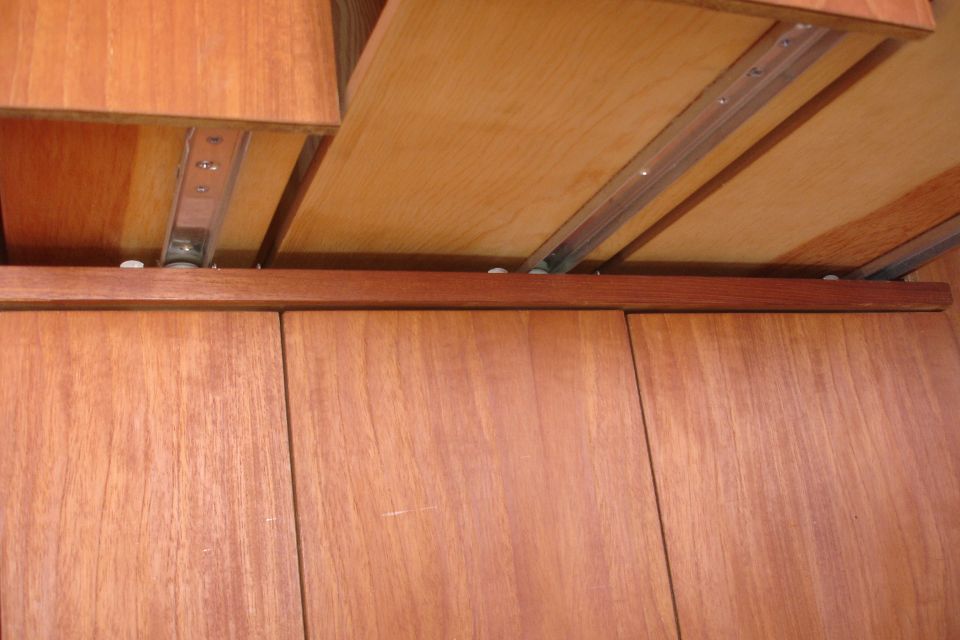 Wooden cabinet with metal drawer slides visible
