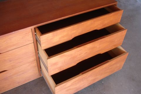 1993 Ford Taurus - A wooden dresser with three open drawers is shown from a side angle, revealing the dark interiors of the drawers.