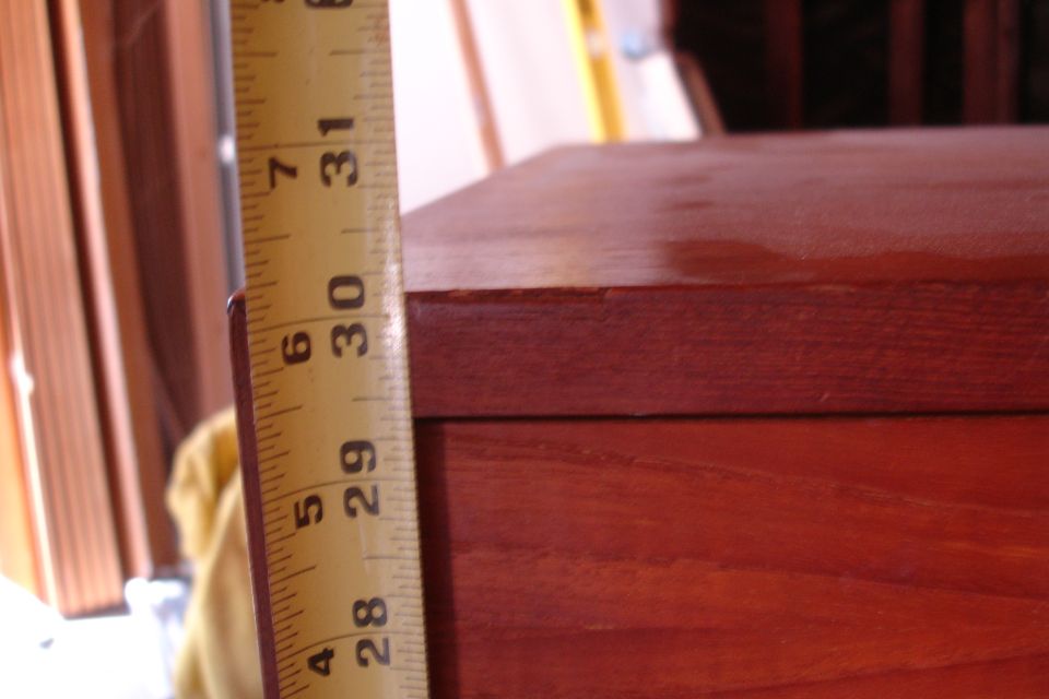 Wooden box with a tape measure showing 28 to 31 inches