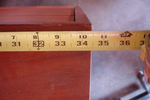 1993 Ford Taurus - A yellow measuring tape is placed on a dark wood surface, showing measurements in inches.