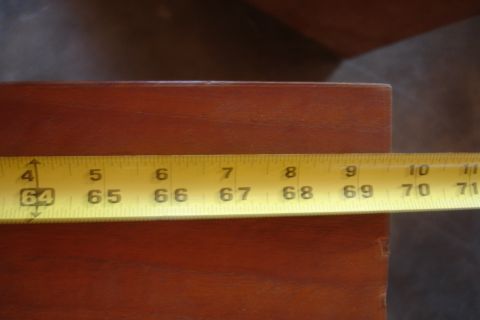 1993 Ford Taurus - A yellow measuring tape is placed on a brown wooden surface, displaying measurements from 64 to 71 inches.