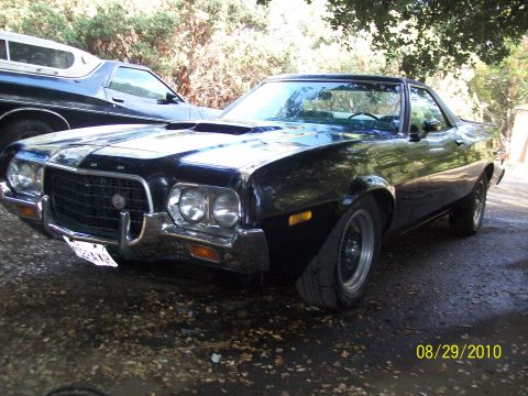 1972 Ford Ranchero - A black 1972 Ford Ranchero is parked outdoors, with another vehicle partially visible behind it.