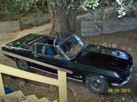 1968 Ford Mustang convertible parked outdoors, front quarter view. Hood scoop and side trim visible