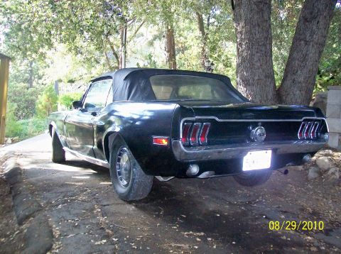 1968 Ford Mustang — Black convertible with a black top, rear view, chrome bumper, and vertical taillights