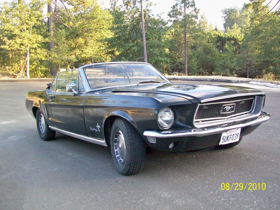 Dark blue 1968 Ford Mustang convertible parked on asphalt, front 3/4 view