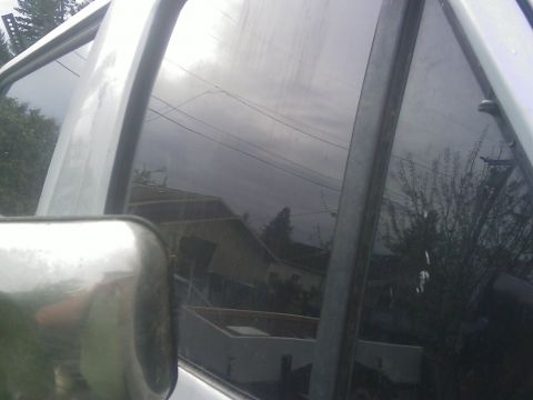 1996 Ford Bronco - Reflection in the window shows houses and trees, with a watermark at the bottom.