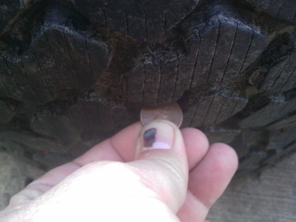 Penny inserted into tire tread to check depth