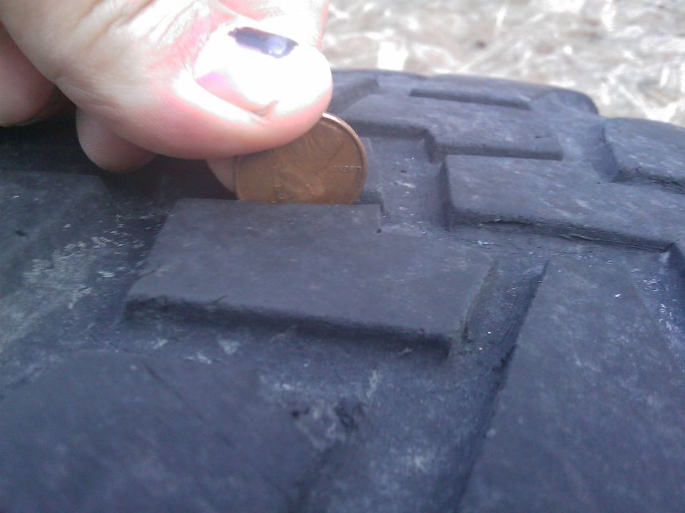 Penny inserted into tire tread to show depth