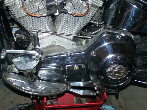 1988 Suzuki Samurai - Close-up view of a motorcycle's engine and drivetrain components, including a chrome-covered primary drive case and footboard.