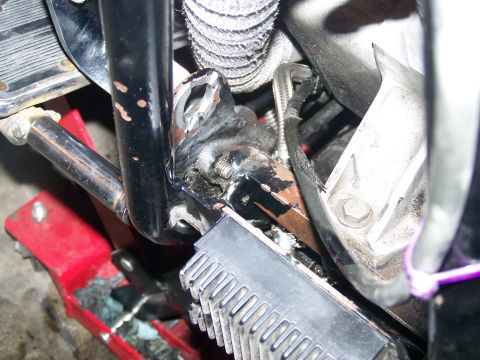 1988 Suzuki Samurai - This image shows a detailed view of a motorcycle's frame and footpeg assembly, with a red jack supporting it.