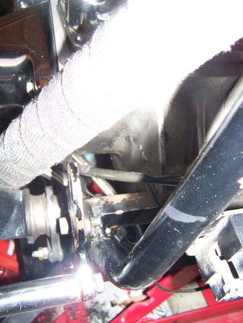 1988 Suzuki Samurai - Close-up view of an exhaust pipe covered in white heat wrap, with surrounding engine components visible.