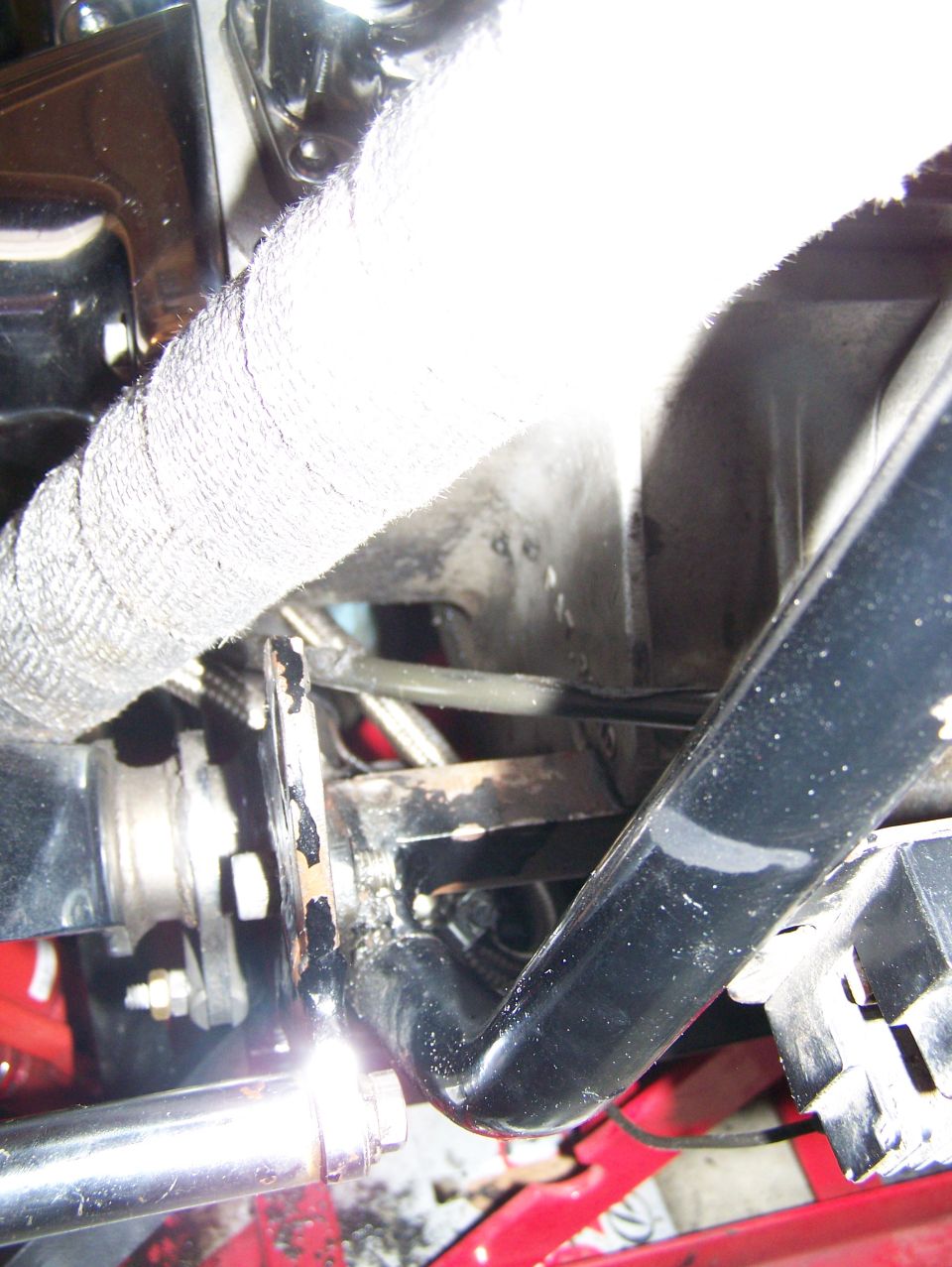 Exhaust pipe with white wrap and black metal bracket