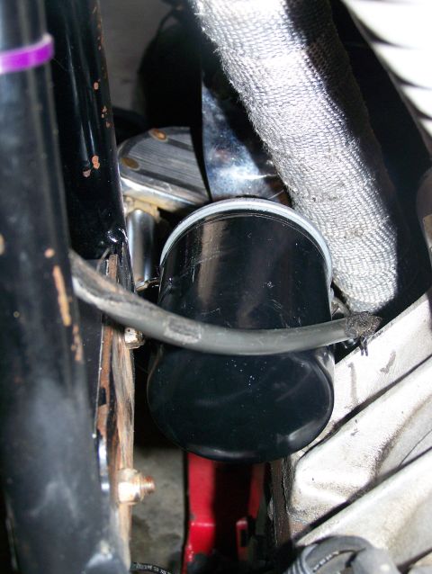 1988 Suzuki Samurai - Close-up view of an oil filter and surrounding engine components, including a heat-wrapped pipe.