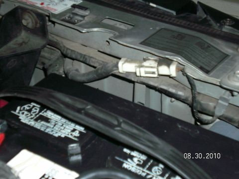 1996 Ford Bronco - Engine bay close-up along the radiator support showing a dusty white two-pin wiring connector spliced into a wiring harness taped along the…