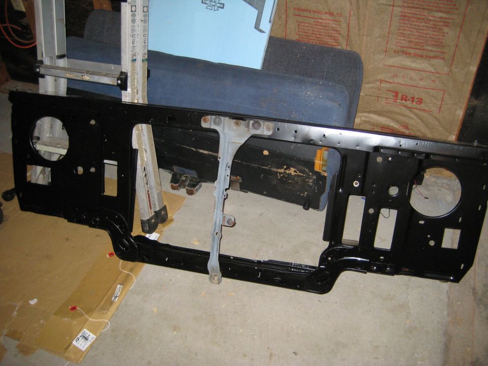 Black radiator support with openings for headlights and grille