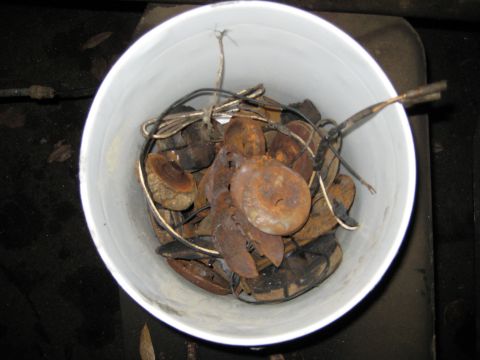 1988 Ford Bronco - Bucket containing assorted rusty metal components and electrical wiring.
