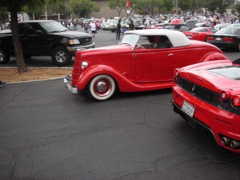 1998 Ford Crown Victoria - A gathering of cars including a classic red convertible and a modern red sports car.