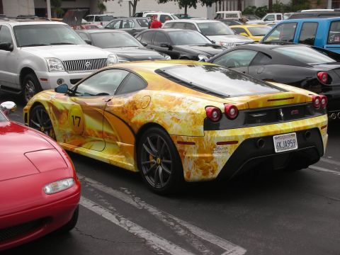 1998 Ford Crown Victoria - A Ferrari F430 with a distinctive flame livery is parked among other vehicles.