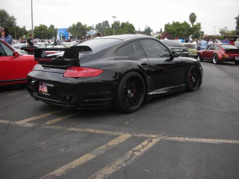 1998 Ford Crown Victoria - Black Porsche 911 Turbo at a car meet, parked next to a red sports car.