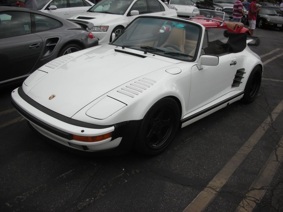 White convertible sports car with black wheels and a red top