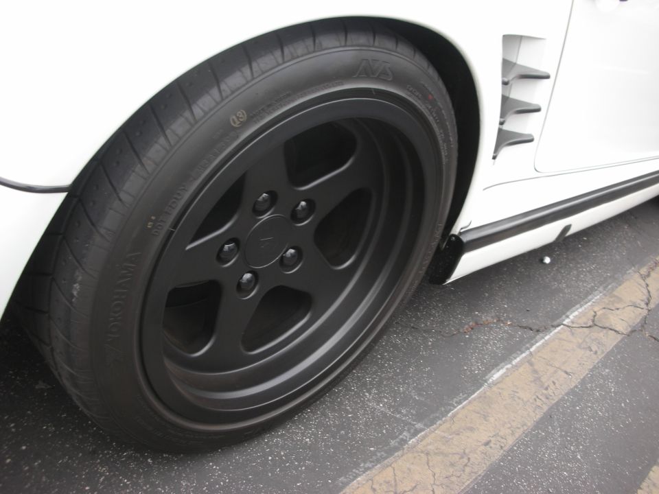White car's front wheel with black five-spoke rims and Yokohama tire