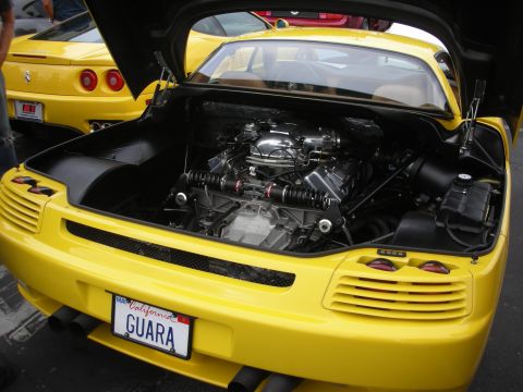 1998 Ford Crown Victoria - Mid-engine layout of a yellow sports car, with a second yellow car in the background.
