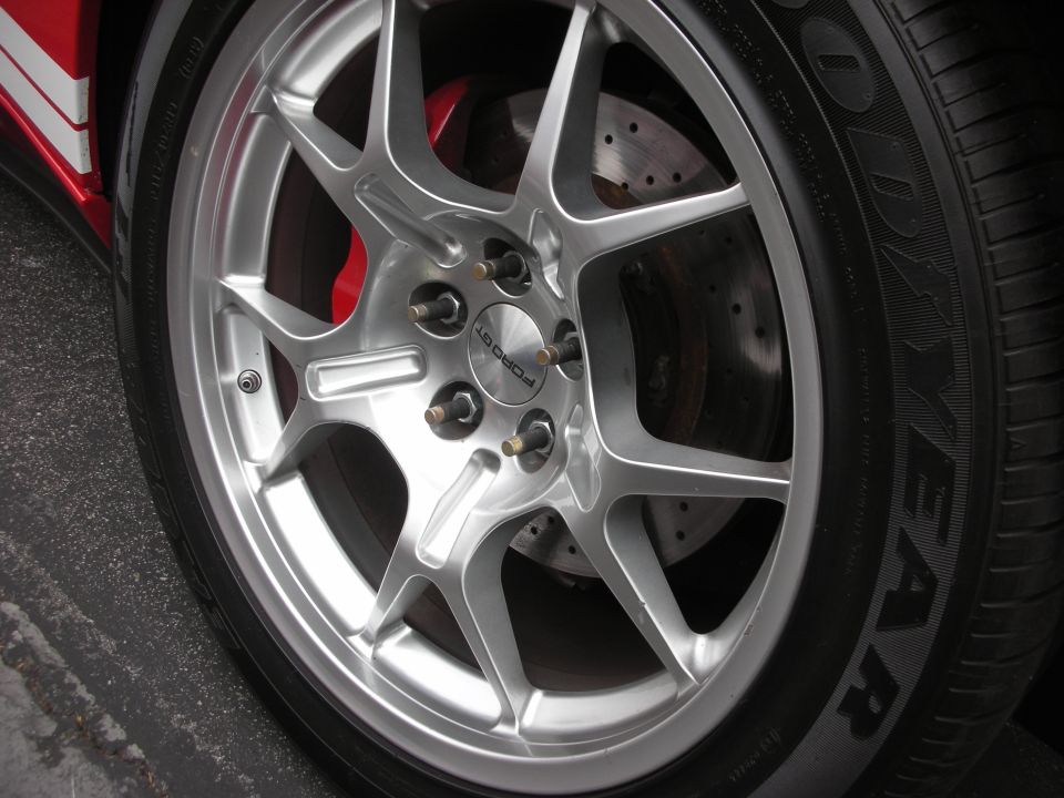 Silver multi-spoke wheel with red brake caliper and Goodyear tire