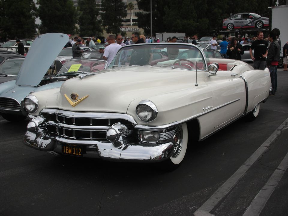 White convertible classic car with chrome grille and red interior. License plate IBW 112