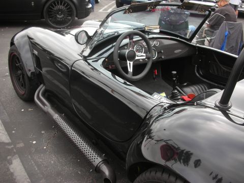 1998 Ford Crown Victoria - A black convertible sports car is parked next to another vehicle.
