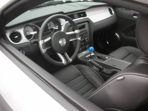 1998 Ford Crown Victoria - The interior of a modern car features black leather seats and a prominent blue gear shift knob.