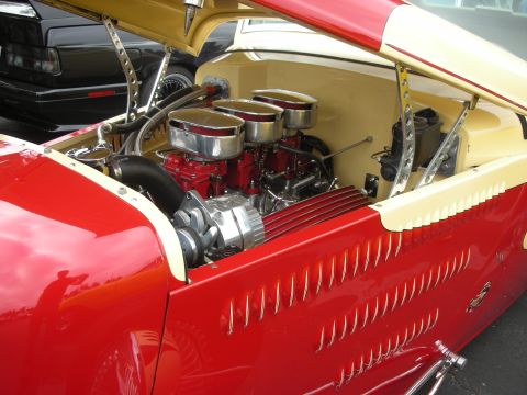 1998 Ford Crown Victoria - A custom hot rod's engine bay is visible with a black car in the background.