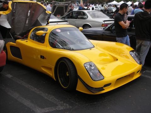 1998 Ford Crown Victoria - Yellow sports car with its front hood open at a car meet event.