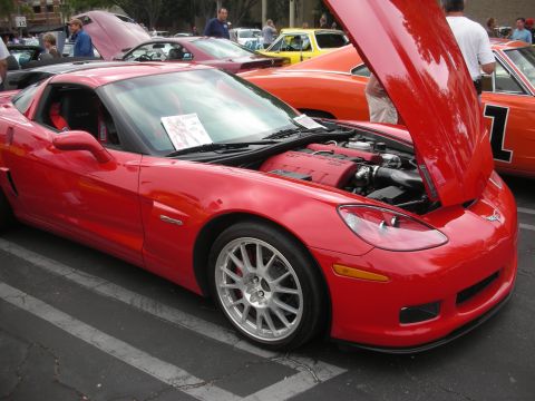 1998 Ford Crown Victoria - A red Chevrolet Corvette is displayed with its hood open, revealing the engine compartment.
