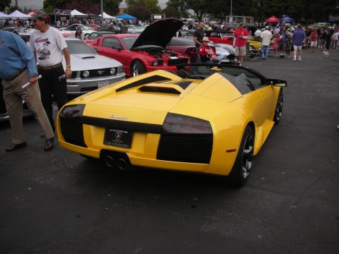 1998 Ford Crown Victoria - Yellow Lamborghini convertible at a car meet, with other cars and attendees visible in the background.