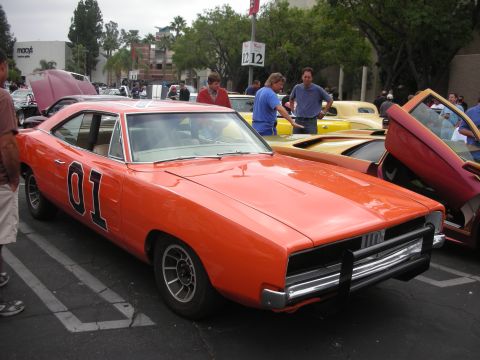 1998 Ford Crown Victoria - A classic orange Dodge Charger, famous from The Dukes of Hazzard, is displayed at an outdoor event.
