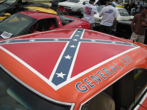 1998 Ford Crown Victoria - An orange car with a confederate flag and "GENERAL LEE" text is parked among other vehicles.
