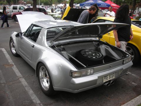 1998 Ford Crown Victoria - A silver sports car is displayed with its trunk and hood open, revealing a spare tire and interior details.