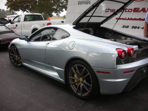 1998 Ford Crown Victoria - A silver Ferrari F430 is parked next to a white pickup truck, with the engine cover open.