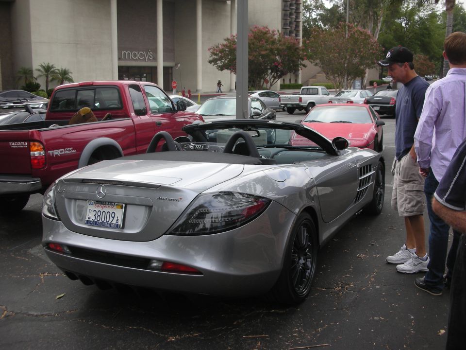 Silver convertible sports car with McLaren badging, rear view