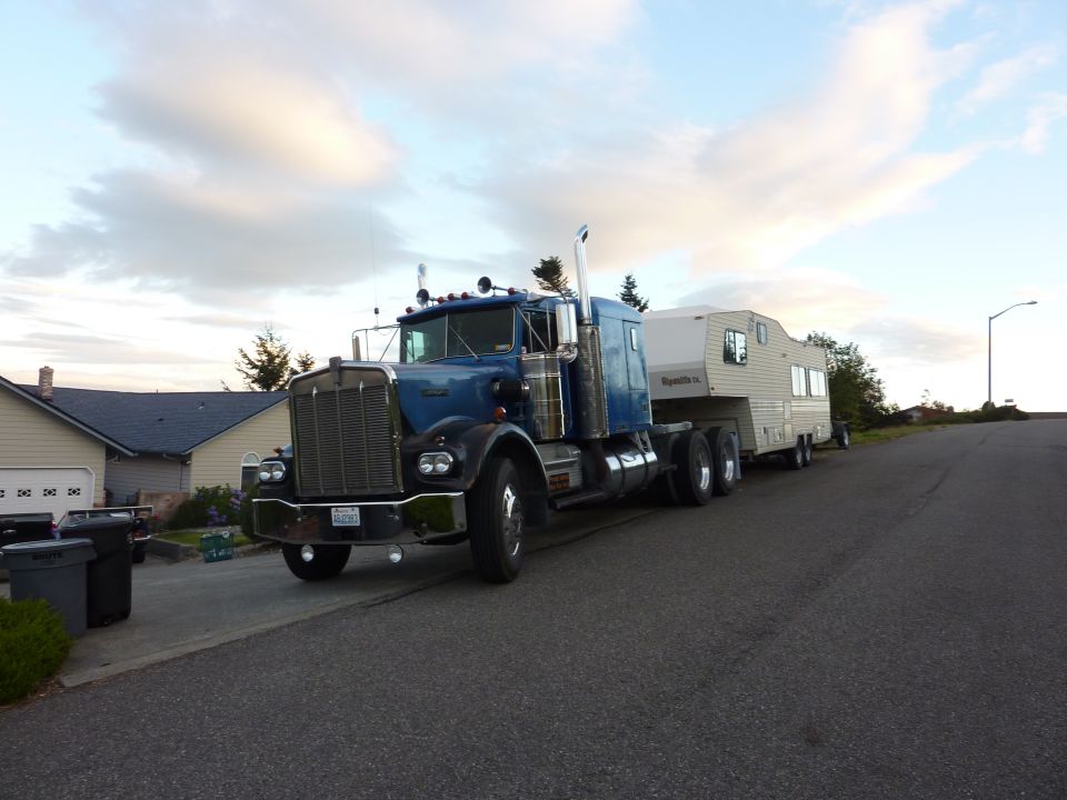 Blue semi-truck with a trailer parked on a residential street
